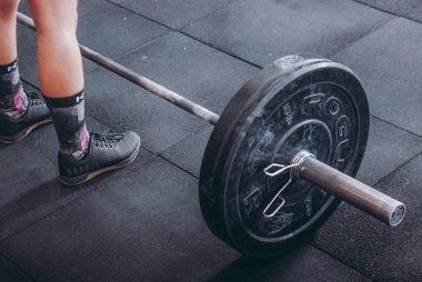 person standing in front of gray and black barbell
